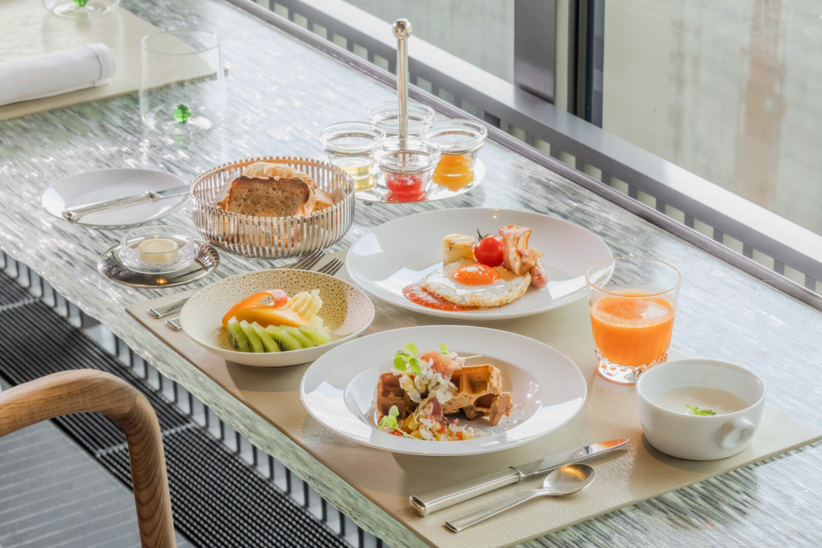 自家製パンやフレッシュジュース、ローストビーフサラダ、季節のフルーツなどが並ぶ、ホテルの朝食セット。