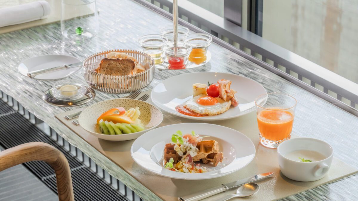 自家製パンやフレッシュジュース、ローストビーフサラダ、季節のフルーツなどが並ぶ、ホテルの朝食セット。