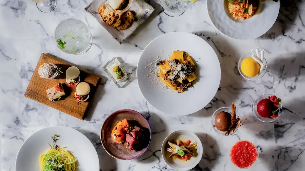 小皿フレンチと泡のドリンクが並ぶリバーサイド ムーンライト ディナーのテーブルセッティング